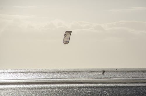 Person Parasailing Under Cloudy Sky