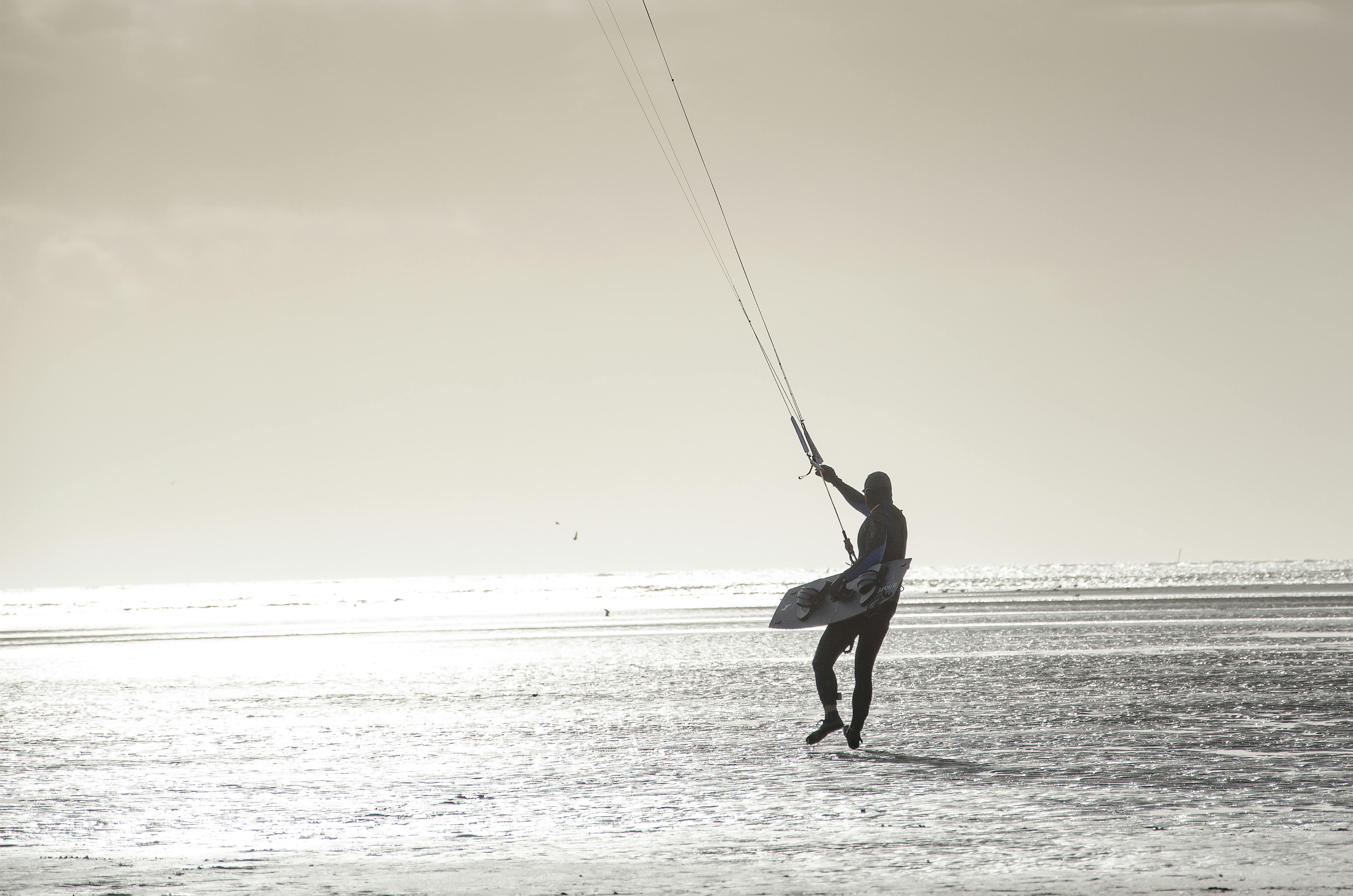 person with parachute strings grayscale photo