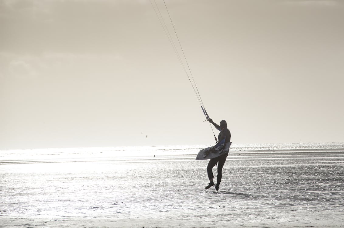 Person With Parachute Strings Grayscale Photo