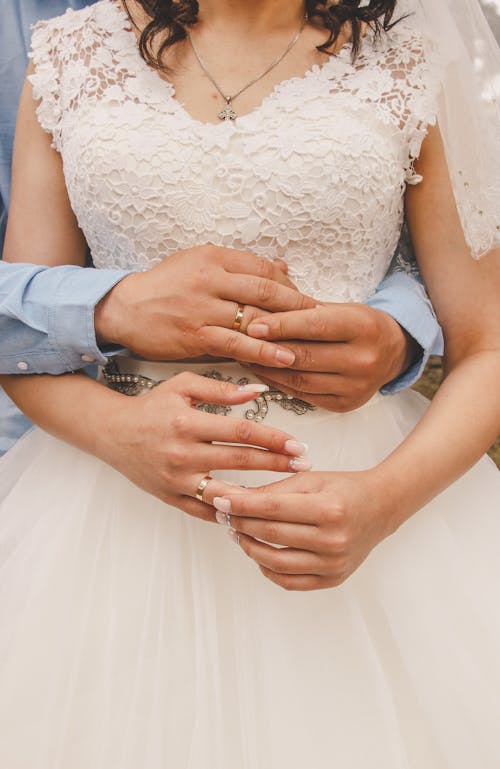 A bride and groom holding hands in a wedding dress