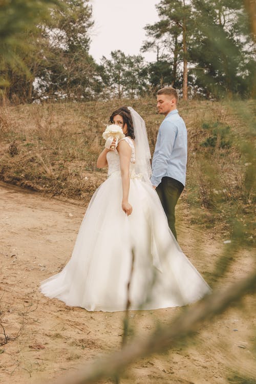 A bride and groom standing in the woods