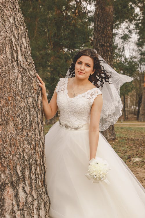 A bride posing in front of a tree