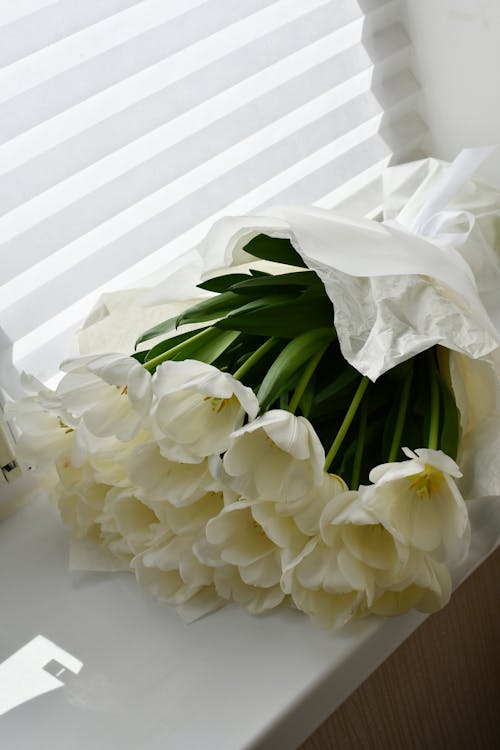 A bouquet of white tulips sitting on a table