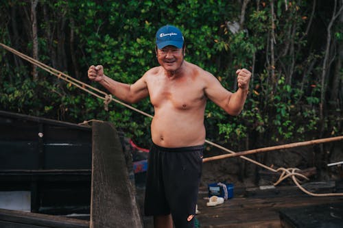 Free A man standing on a boat with his hands up Stock Photo