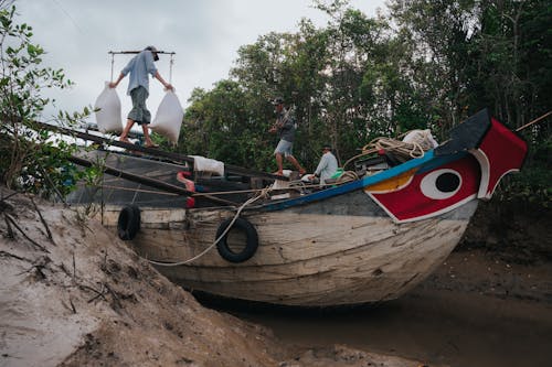Free A boat with people on it in the mud Stock Photo