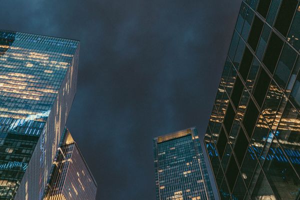 Low-angle view of illuminated financial-district towers at dusk — photo by Artem Balashevsky on Pexels