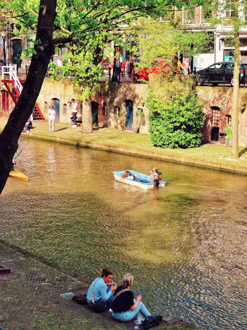 Two people sitting on a bench near a river