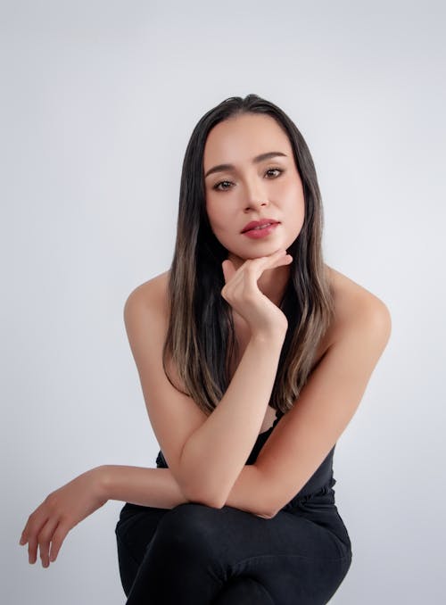 A woman in black sitting on a stool