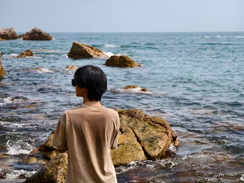 Back View of a Boy Standing on a Beach