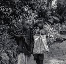 Two young boys in Burundi stand in a lush, green setting, showcasing childhood curiosity.