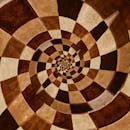 画布上，错综复杂的螺旋设计以泥土色调创造出迷人的抽象艺术