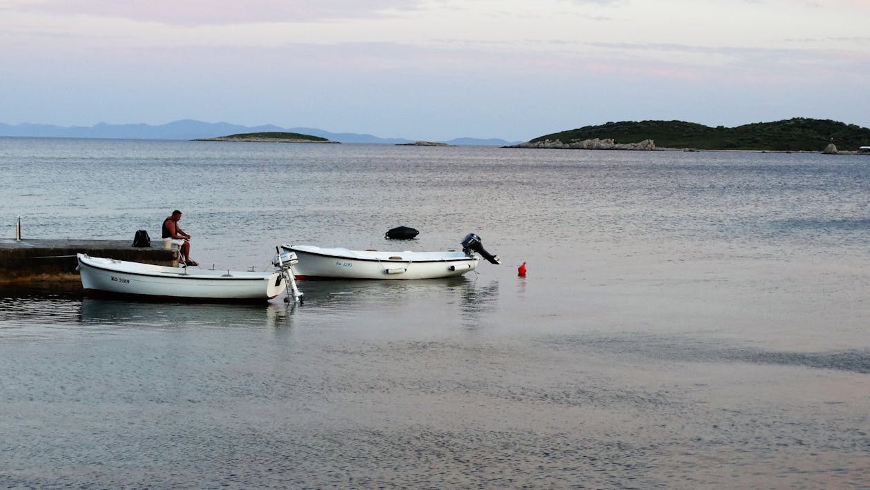 бесплатная 2 Белая лодка на пляже в дневное время Стоковое фото