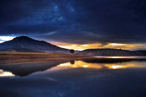 免费 黎明时分穿过平静的河水所见的山景 素材图片