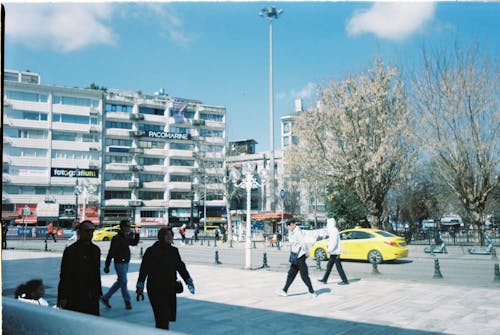 People walking in a city square with buildings in the background