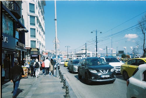 A busy street with cars and people walking