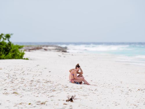 A couple sitting on the beach with their dog