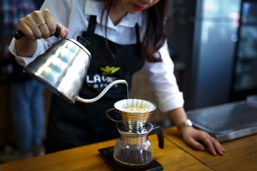 Frau, Die Kaffee In Tasse Gießt