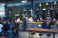 一家充满活力的咖啡店里，顾客和咖啡师在活跃的氛围中忙碌着