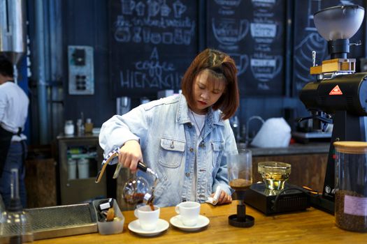 在一家别致现代的咖啡店里，一位专注的咖啡师正小心翼翼地将咖啡倒入杯中