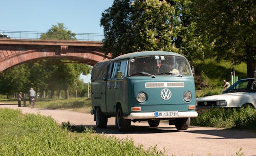 A green vw bus is parked on the side of the road