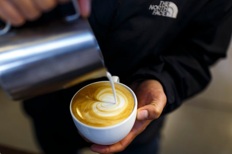 Person Pouring Cream To Coffee