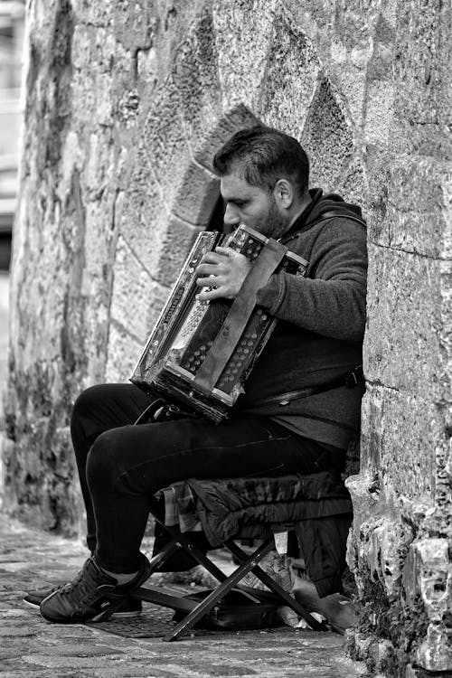 A man playing an accordion in a stone wall