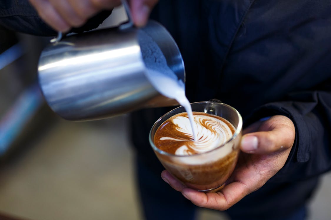 Free Person Pouring Milk on Coffee Stock Photo