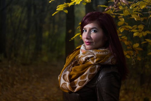 Woman Wearing Brown and White Scarf Surrounded by Trees at Daytime