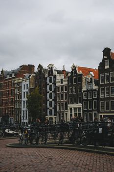 Picturesque canal houses in Amsterdam with bikes and cobblestone streets.