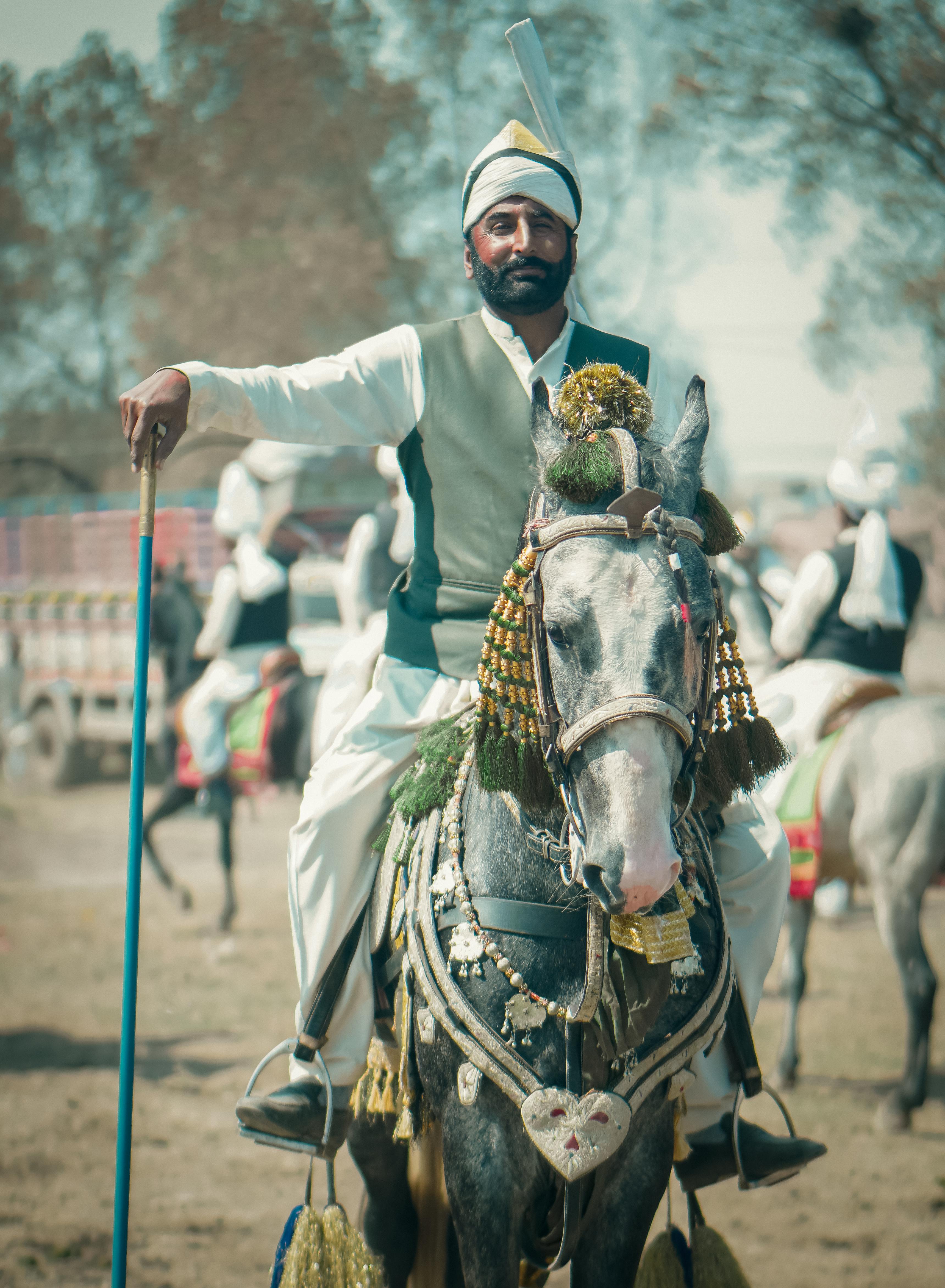 bearded man riding a horse wearing a decorative bridle