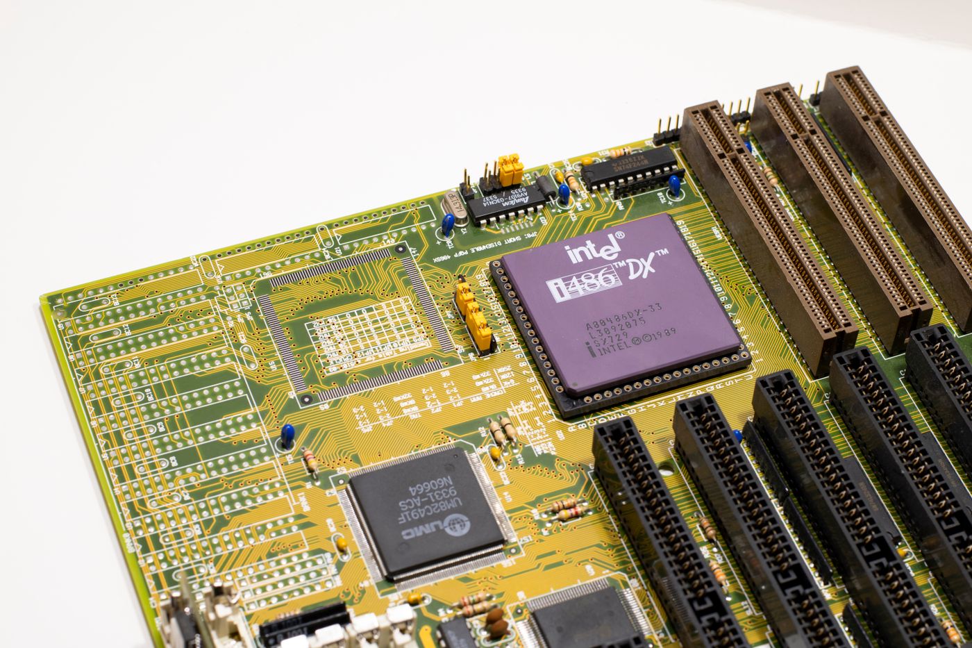 Close-up of a vintage Intel 486 CPU motherboard with PCI slots, highlighting retro technology components.