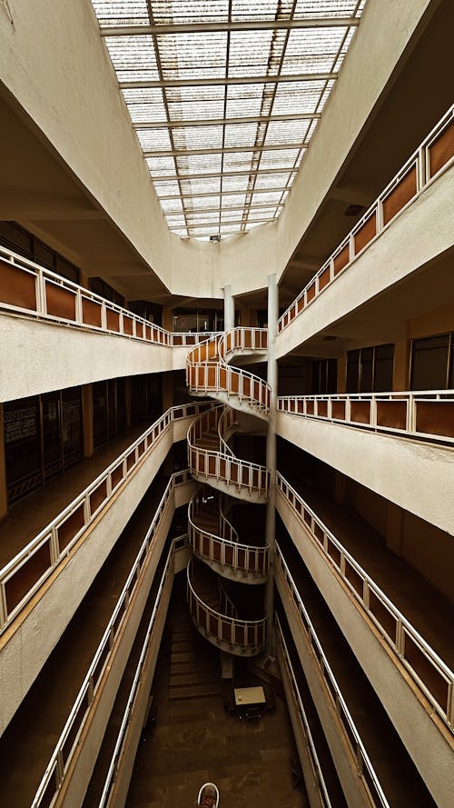 A spiral staircase in a building with a glass roof