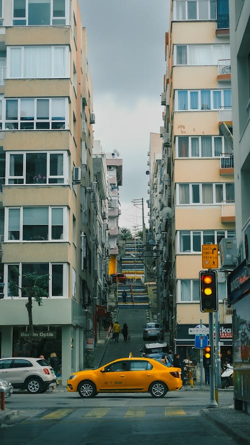 A yellow taxi is driving down a street