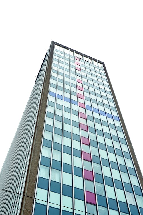 A tall building with a pink and blue window