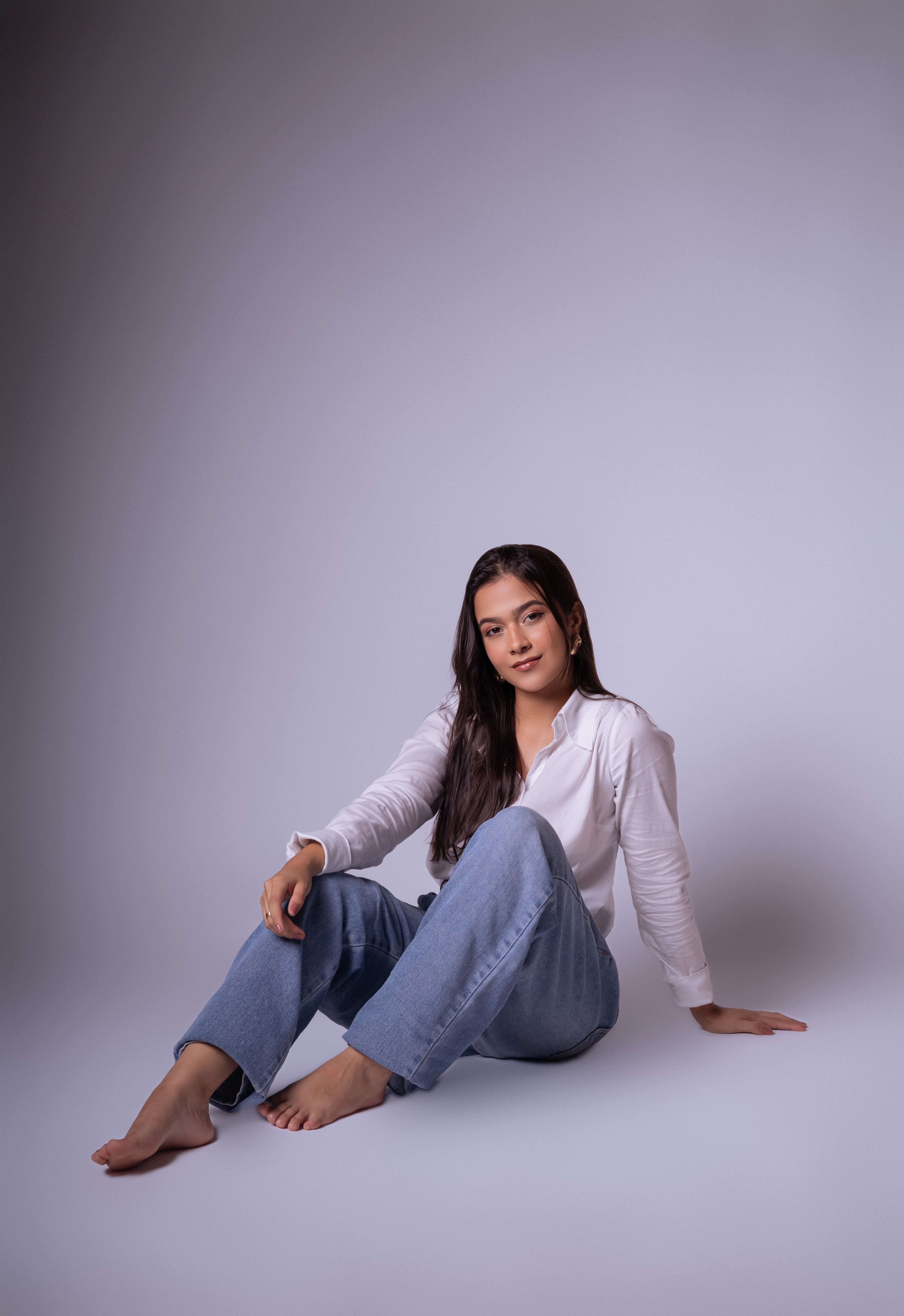 Brunette Woman Sitting in Jeans and Shirt · Free Stock Photo