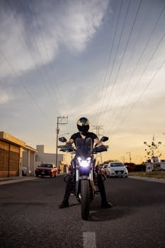 Motorcyclist on a quiet suburban street at sunset, showcasing urban exploration.