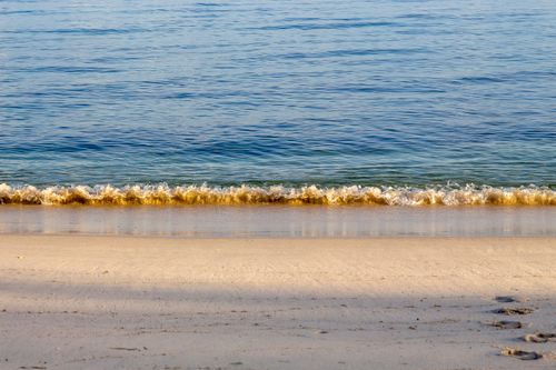 Free Peaceful view of gentle waves lapping against the sandy shore at Shoal Bay, NSW, Australia. Stock Photo