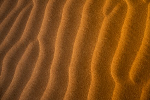 Sand dunes in the desert with orange and brown lines