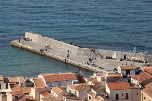 A view of the sea and a pier with a few buildings