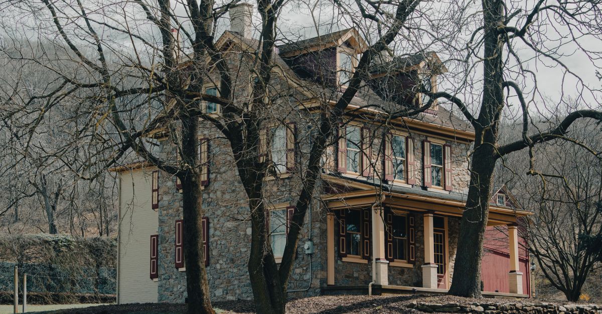 A classic stone house surrounded by bare trees on a winter day in Bethlehem, PA.