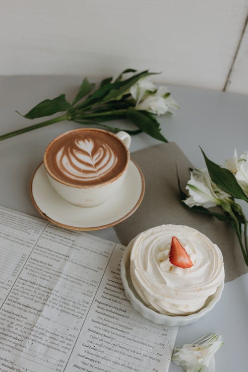 Free A cup of coffee and a cupcake on a newspaper Stock Photo