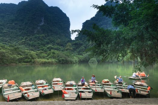宁静的湖面上船只排列，周围青山环绕，郁郁葱葱，非常适合旅行和自然爱好者