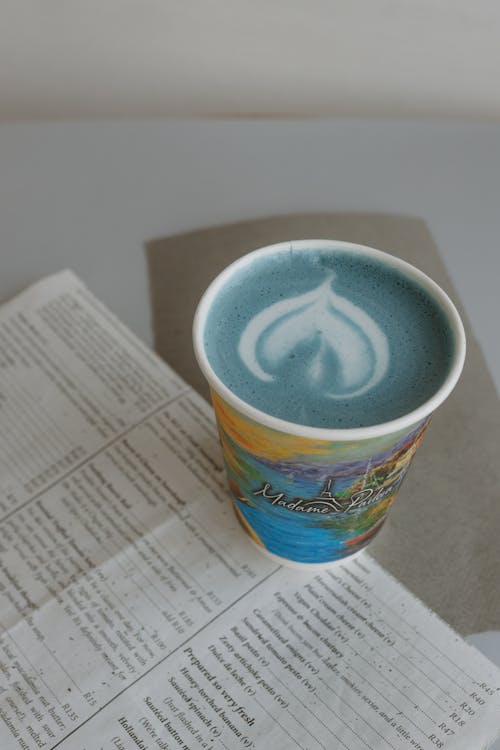 A cup of coffee with a blue liquid on top