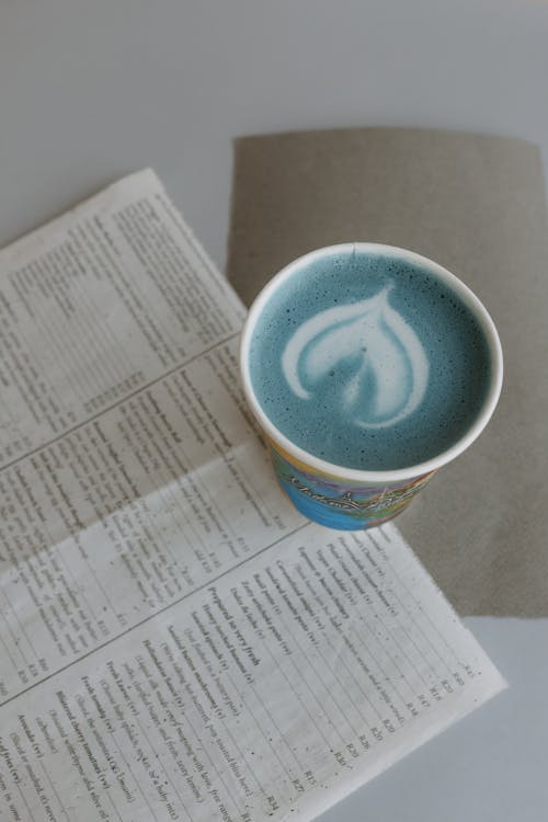 A cup of coffee with a blue flower on top