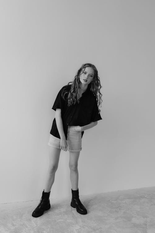 Free A woman in black shirt and shorts standing in a black and white photo Stock Photo