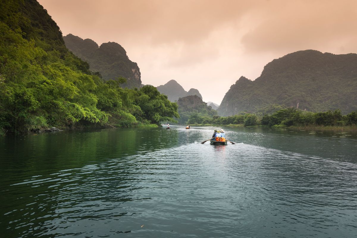 River winding between green limestone mountains in Ninh Binh