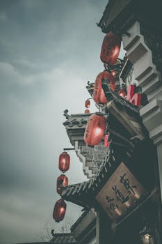 多云天空下，传统建筑上挂着红灯笼的街景显得格外大气