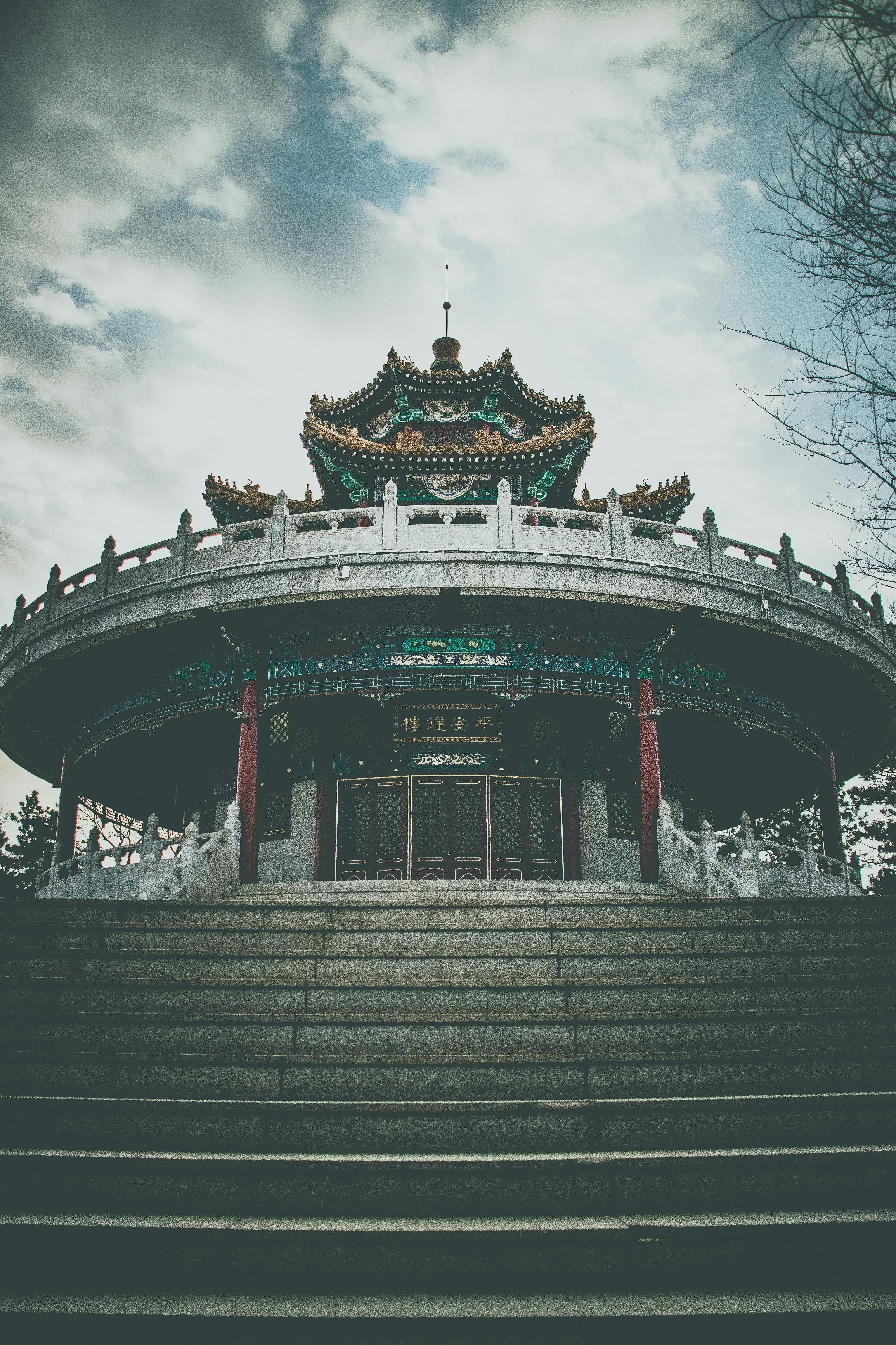 一座拥有复杂建筑细节和华丽屋顶的传统亚洲寺庙，矗立在多云的天空下