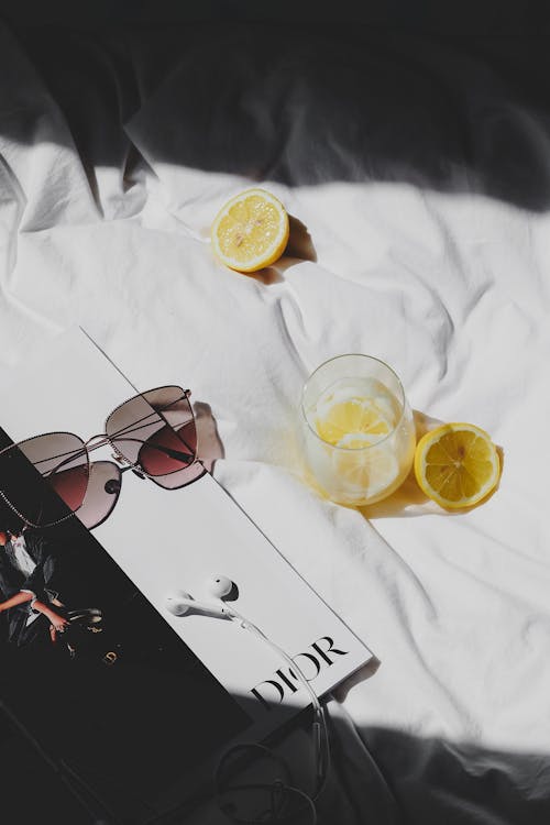 Free A magazine, sunglasses and lemon slices on a bed Stock Photo