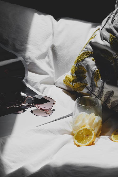 Free A bed with a laptop, a glass of lemonade and a book Stock Photo